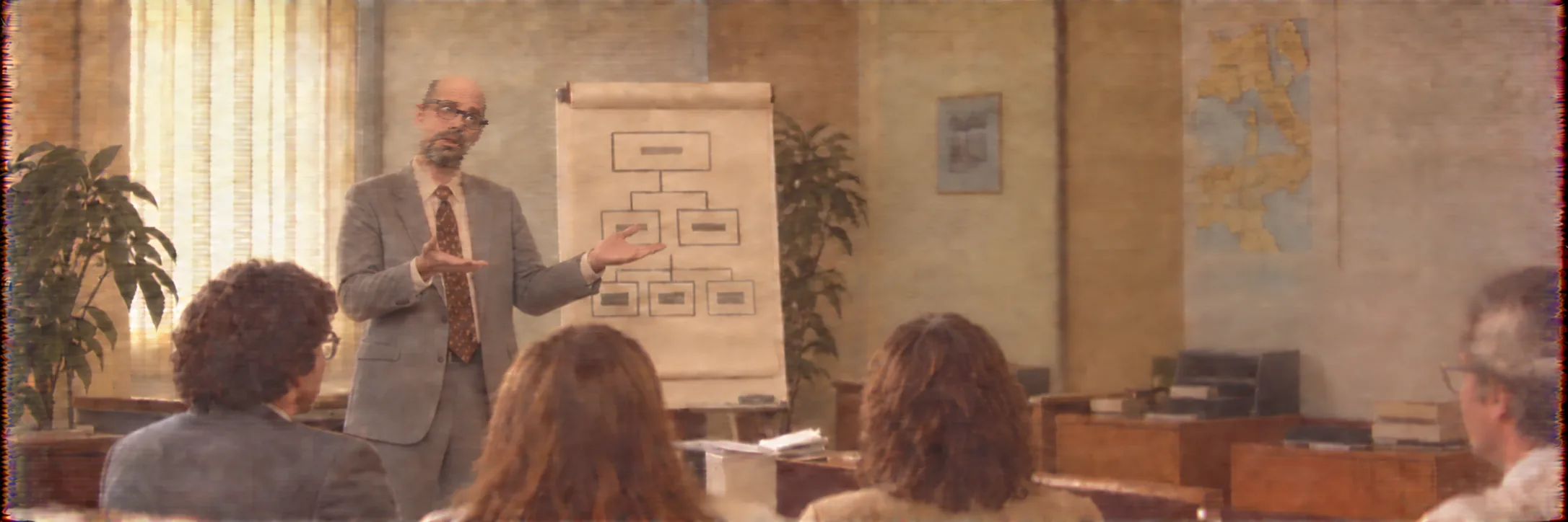 Une réunion de travail devant un tableau à feuilles, dans un bureau des années 1980